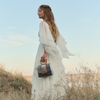 Model holding the limited edition ANIMA Sandy Povitrulia designer bag at golden hour by BLACKWOOD