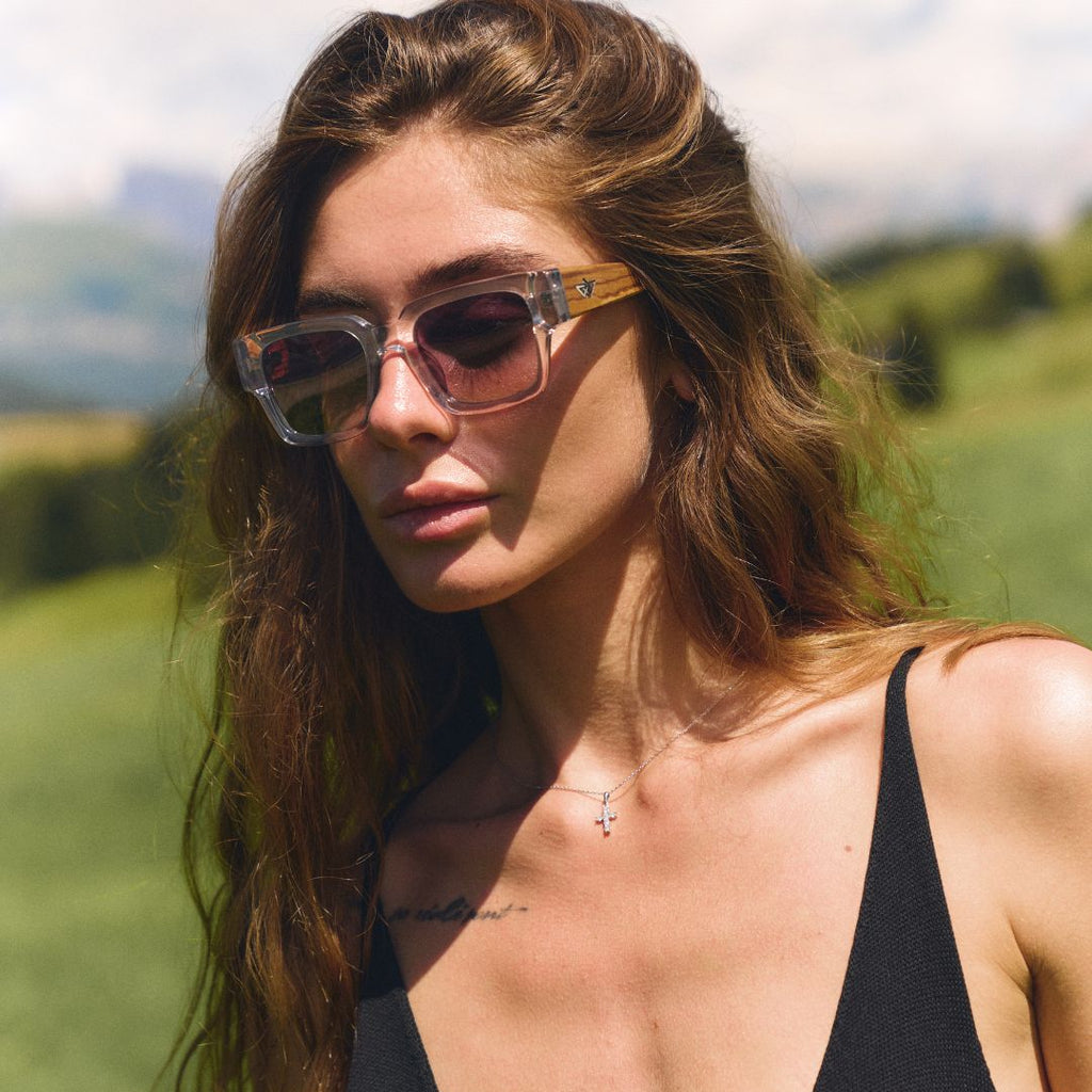 Woman wearing sunglasses and a black top in a natural setting