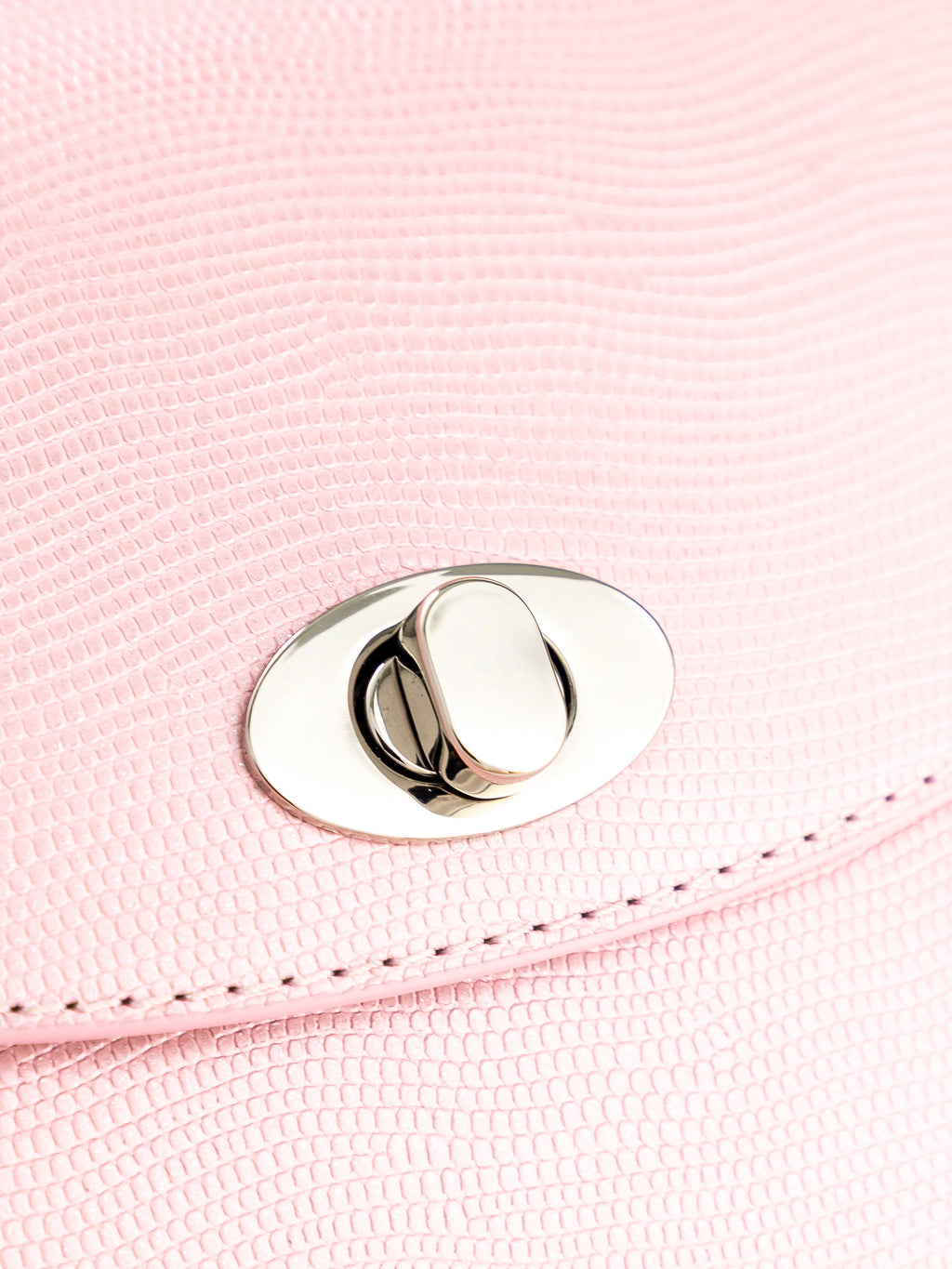 Close-up of shiny rose leather texture and metal clasp on BLACKWOOD Aurora handbag