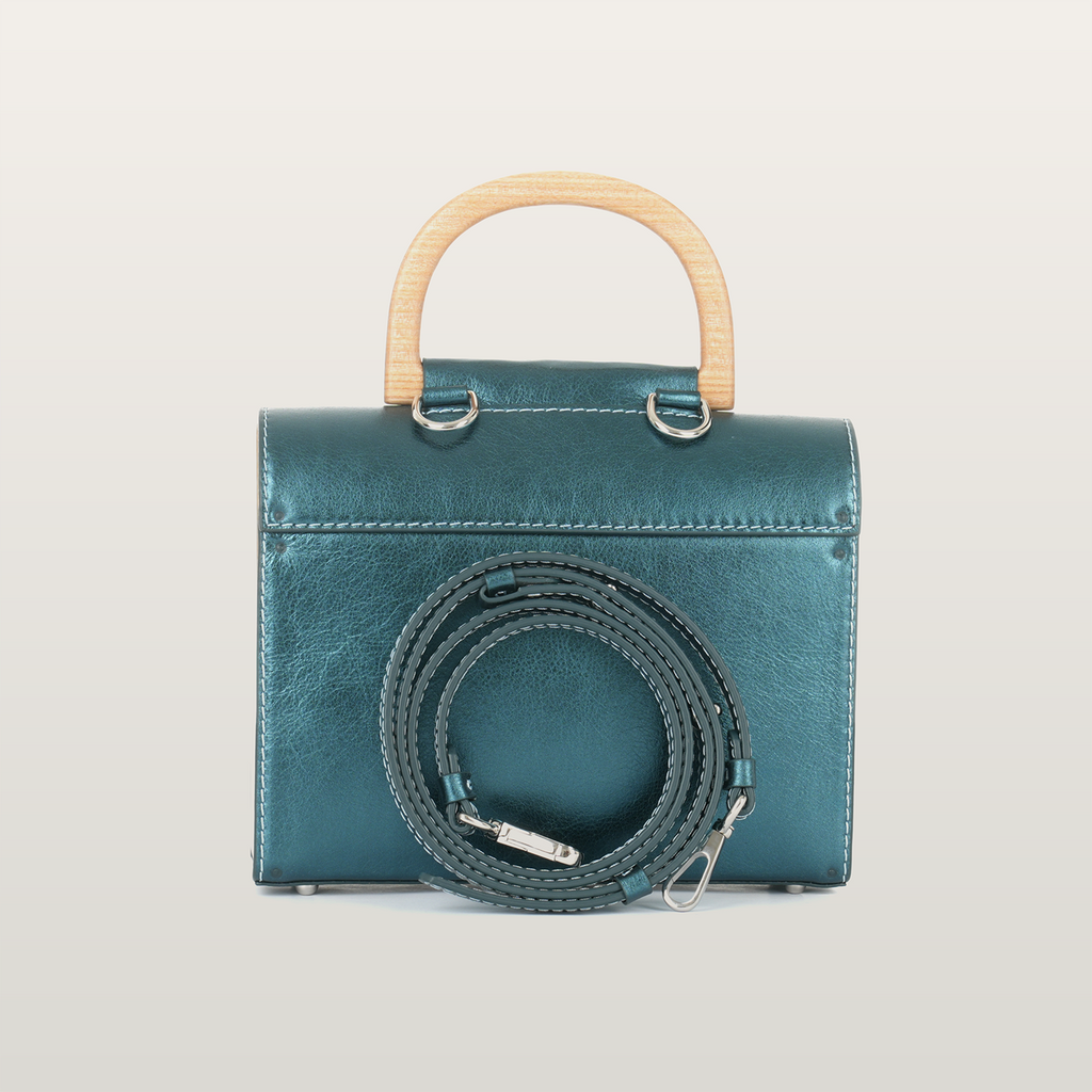 Back view of Aurora Vodianytsia bag showing detachable crossbody leather strap and steel hardware