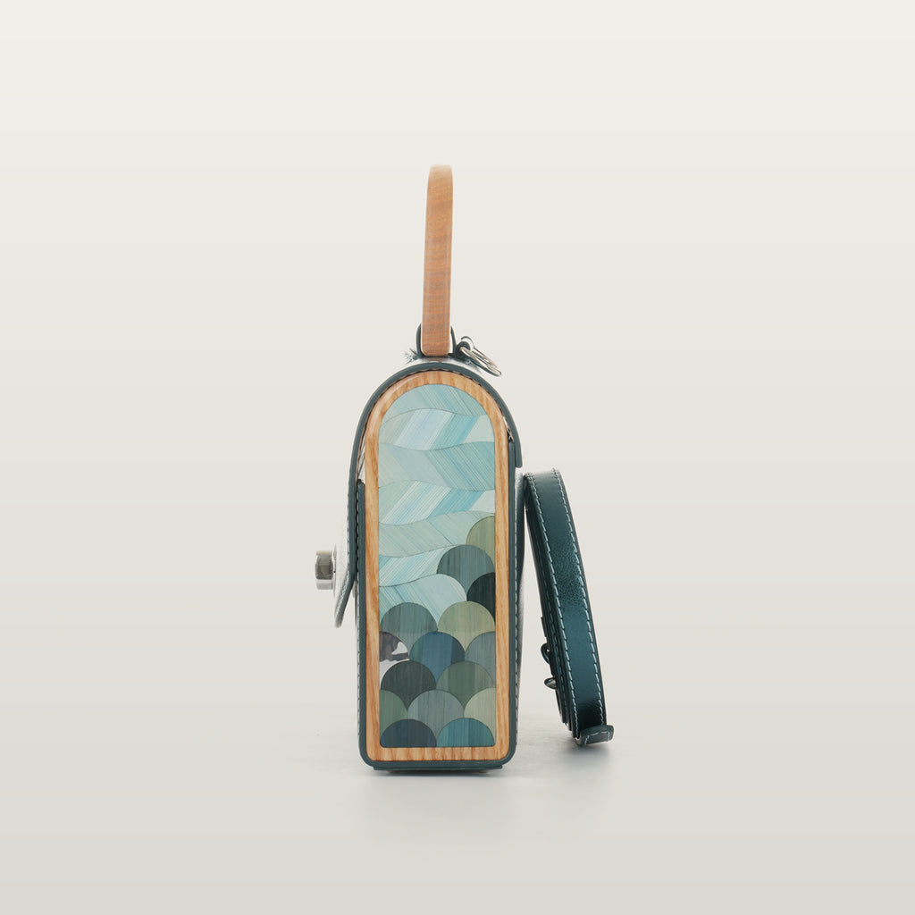 Side view of Aurora Vodianytsia bag showcasing wave-inspired rye straw marquetry sealed under clear resin