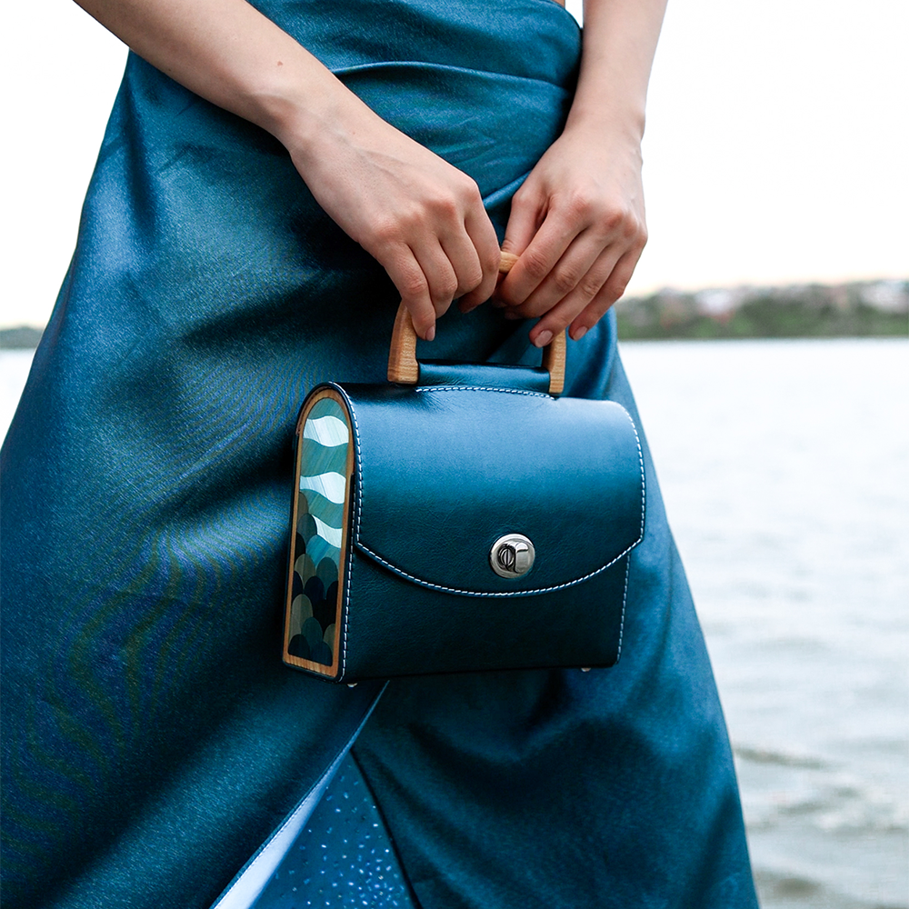 Handcrafted Aurora Vodianytsia bag with metallic teal leather and custom round lock detail