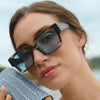 Woman wearing sunglasses with a blurred natural background