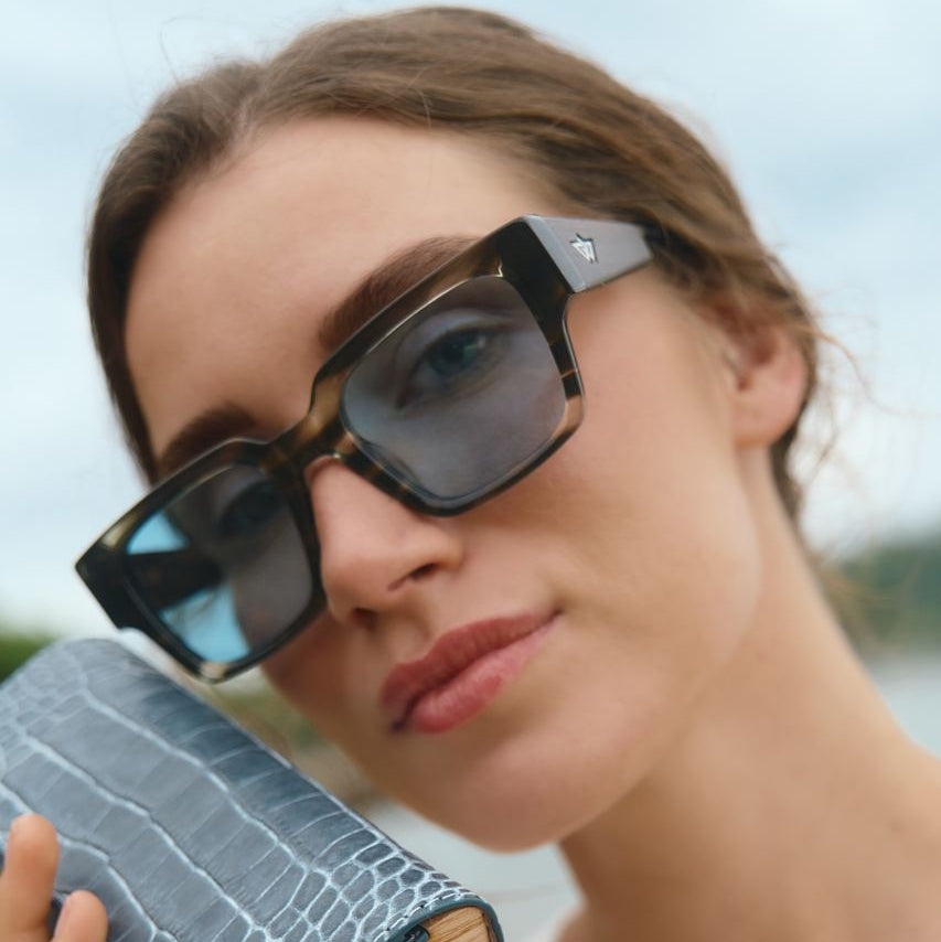 Woman wearing sunglasses with a blurred natural background